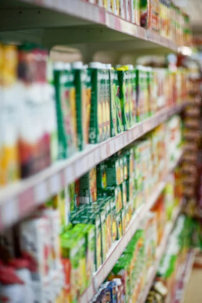 Estantes con zumos en un supermercado . — Foto de Stock
