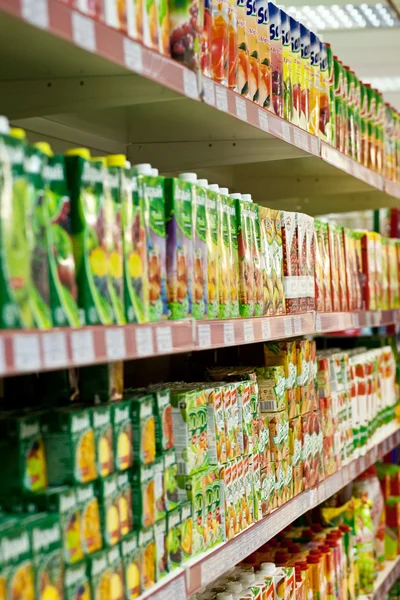 Estantes con zumos en un supermercado . — Foto de Stock