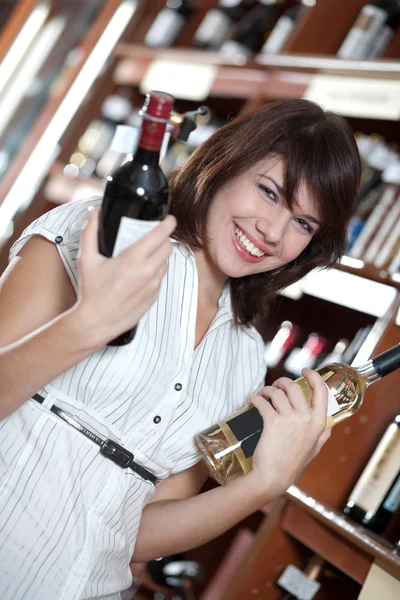 Stock image Young girl chooses wine in a supermarket