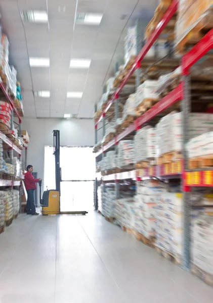 stock image Yellow fork lifter work in big warehouse