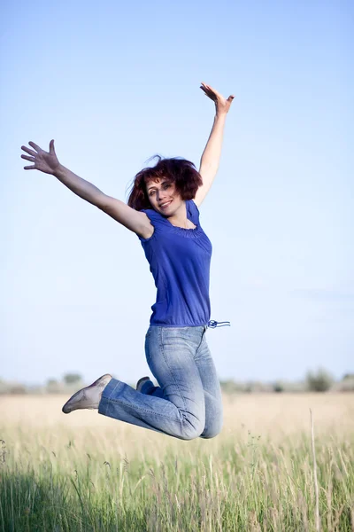 Stock image Woman jumping in grass