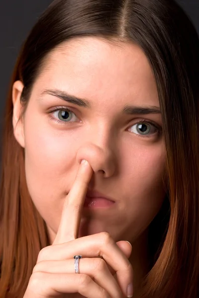 La muchacha mete el dedo en la nariz — Foto de Stock