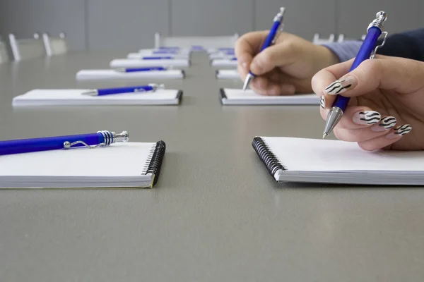 Mão segurando uma caneta em uma mesa cinza — Fotografia de Stock