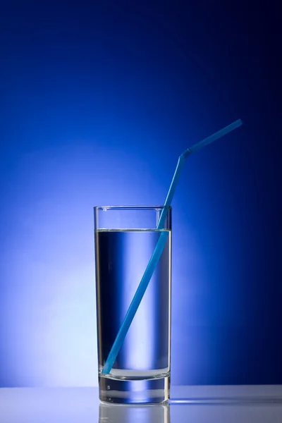 Vidro com água pura com palha azul — Fotografia de Stock