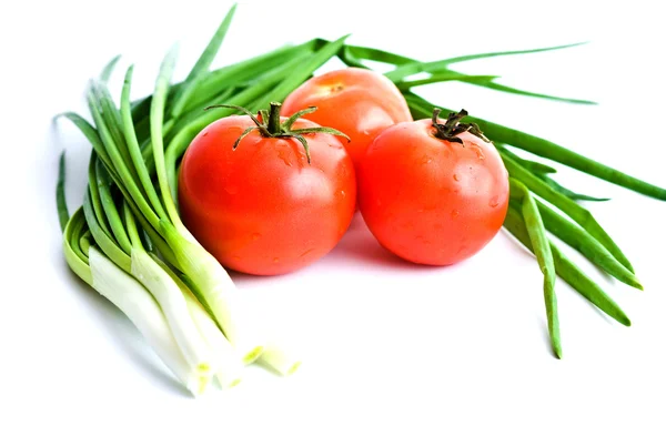 Três tomates vermelhos e cebolas verdes — Fotografia de Stock