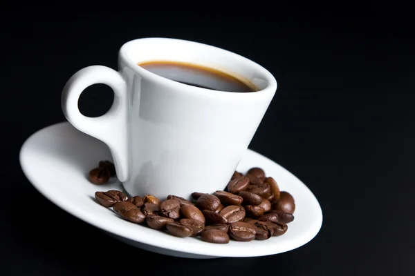 Kopp kaffe med bönor kaffe på svart — Stockfoto