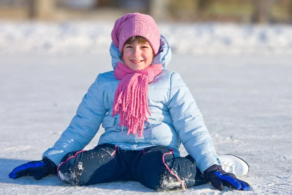 Chica en patines sentado en el hielo . — Foto de Stock