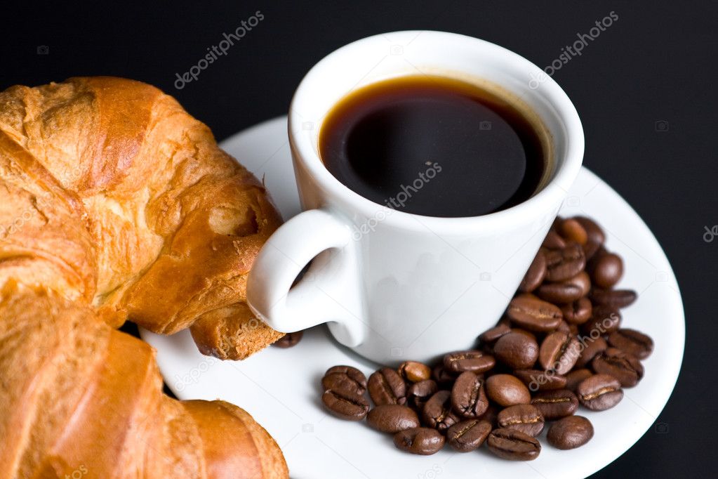 White cup coffee and croissant on black