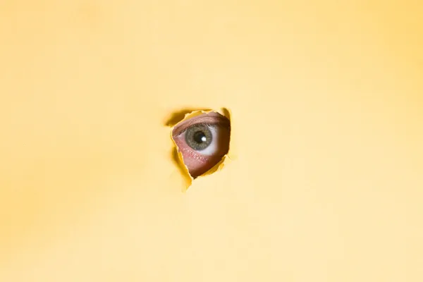 stock image Eye peeking through a hole