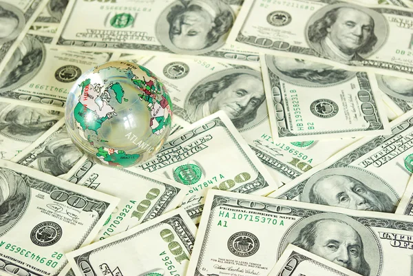 Глобус на долларах — стоковое фото