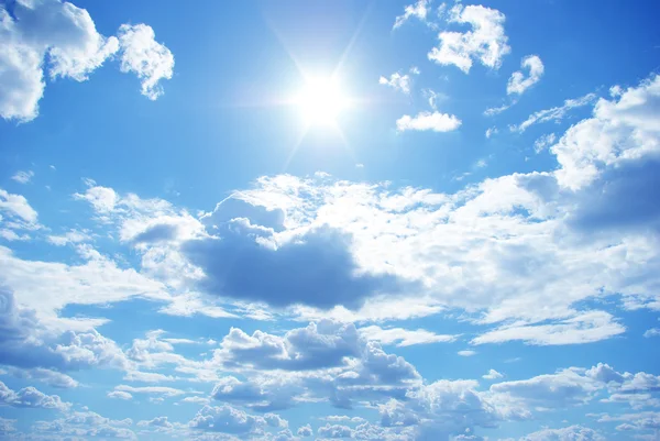 Zon in een blauwe bewolkte hemel Stockfoto