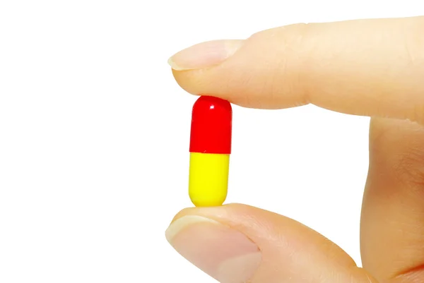 Dedo segura pílula — Fotografia de Stock