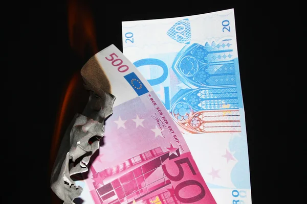stock image money and fire on the black background, crisis concept 