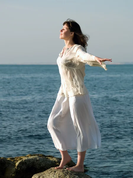 Mujer joven en piedra del mar mirando recto —  Fotos de Stock