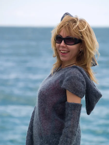 Blond modell i huva poserar beach — Stockfoto