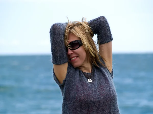 Biondo modella in cappuccio osare spiaggia — Foto Stock