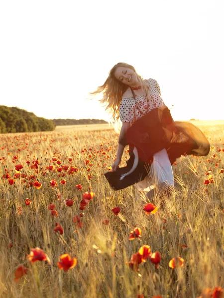 Blonde walking in poppy field — Stock Photo, Image