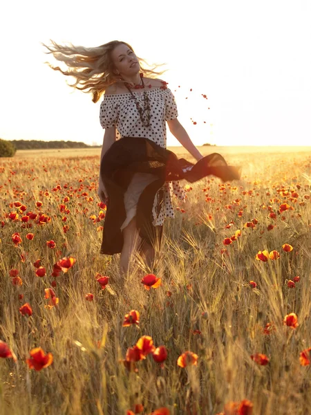 Blonde walking in poppy field — Stock Photo, Image