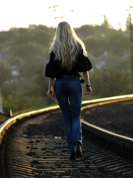 Mujer joven caminando por el ferrocarril — Foto de Stock