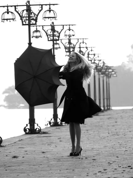 Блондинка с зонтиком на набережной — стоковое фото