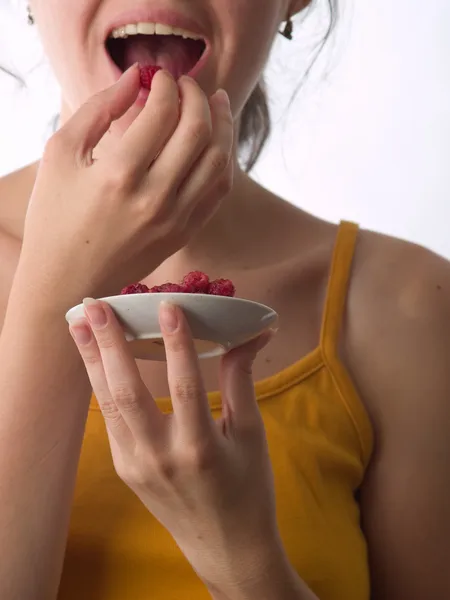 Girl eating raspberry — Stock Photo, Image