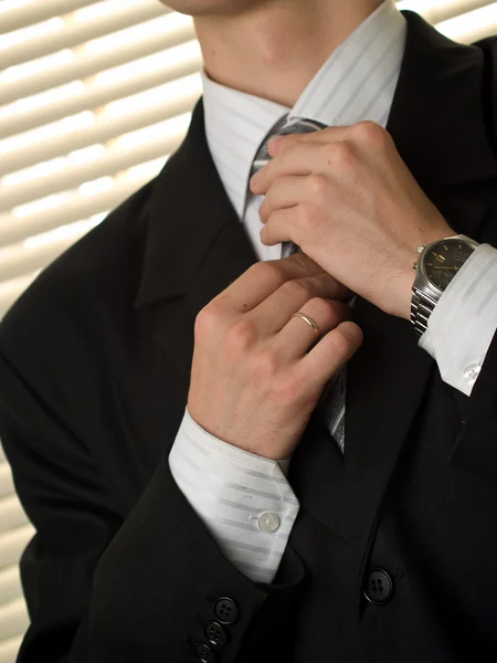 Junger Kaufmann bindet Krawatte lizenzfreie Stockbilder