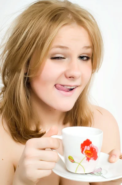 Attractive sexy nude woman holding a cup and drinking. Side view