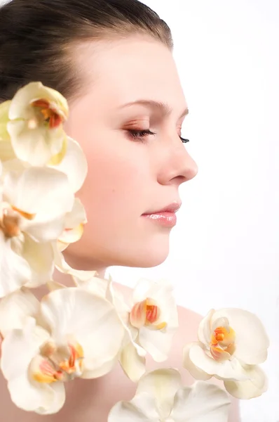 Die schöne junge Frau mit den Blumen — Stockfoto