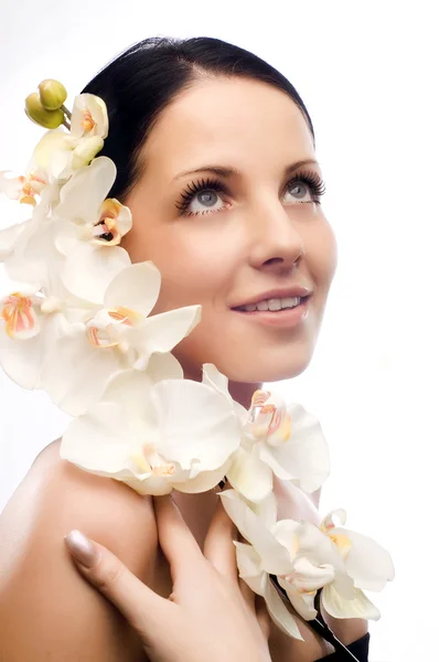 De mooie jonge vrouw met bloemen — Stockfoto
