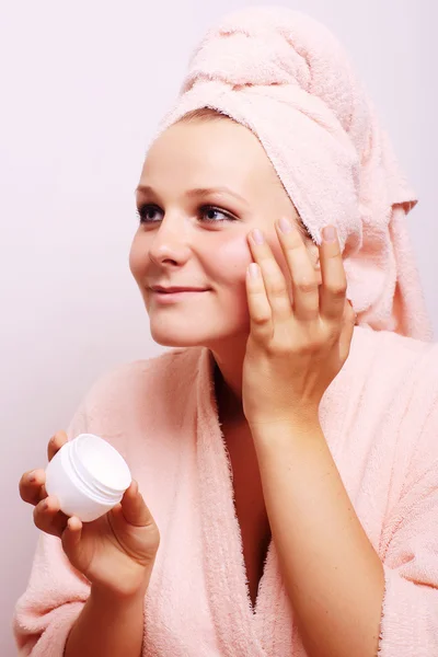 Mujer joven aplicando crema en la cara —  Fotos de Stock