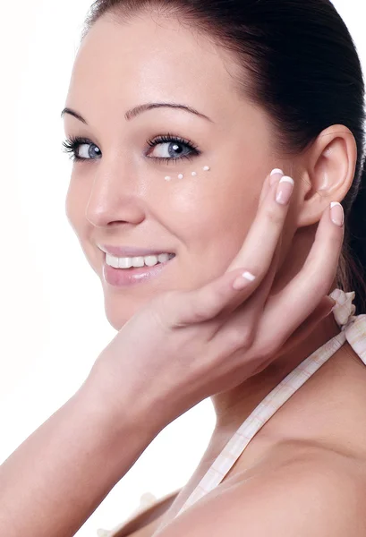 Young woman applying creme on face Royalty Free Stock Photos