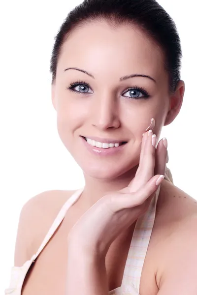 Mujer joven aplicando crema en la cara — Foto de Stock