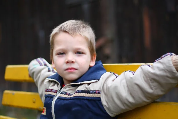 Bankta oturan küçük çocuk — Stok fotoğraf