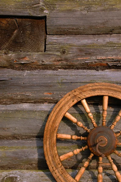 Roda giratória na parede da cabana de log — Fotografia de Stock
