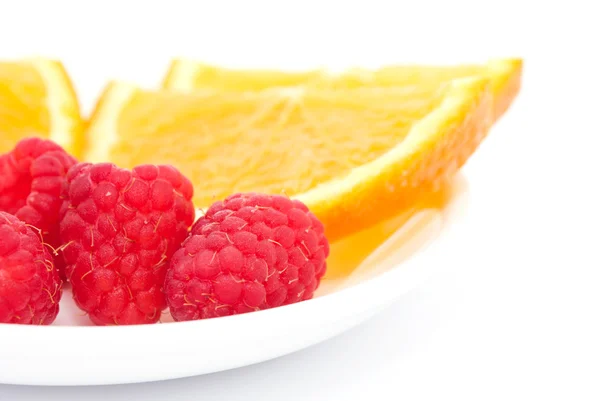Raspberries and sliced orange — Stock Photo, Image