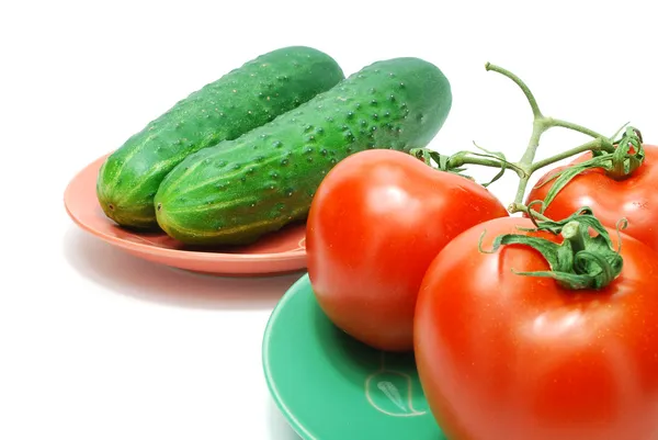 Красные помидоры и огурцы на тарелке — стоковое фото