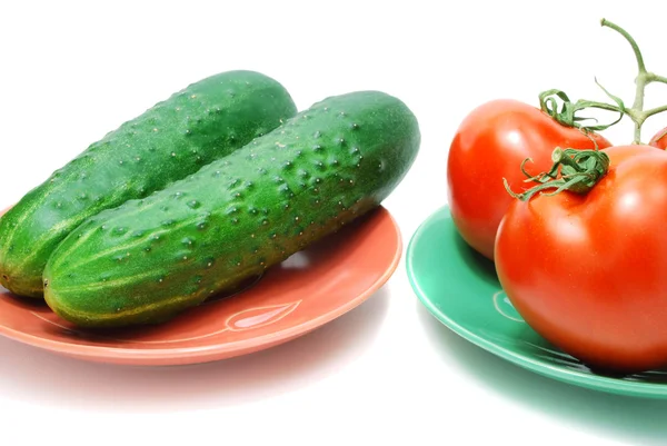 Красные помидоры и огурцы на тарелке — стоковое фото