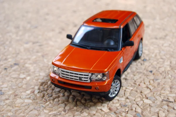 stock image The toy car on cobblestone road