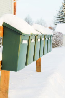 A row of green mailboxes draped with a layer of clipart