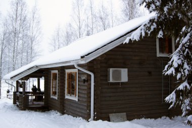 Casita de madera cubierto por la nieve