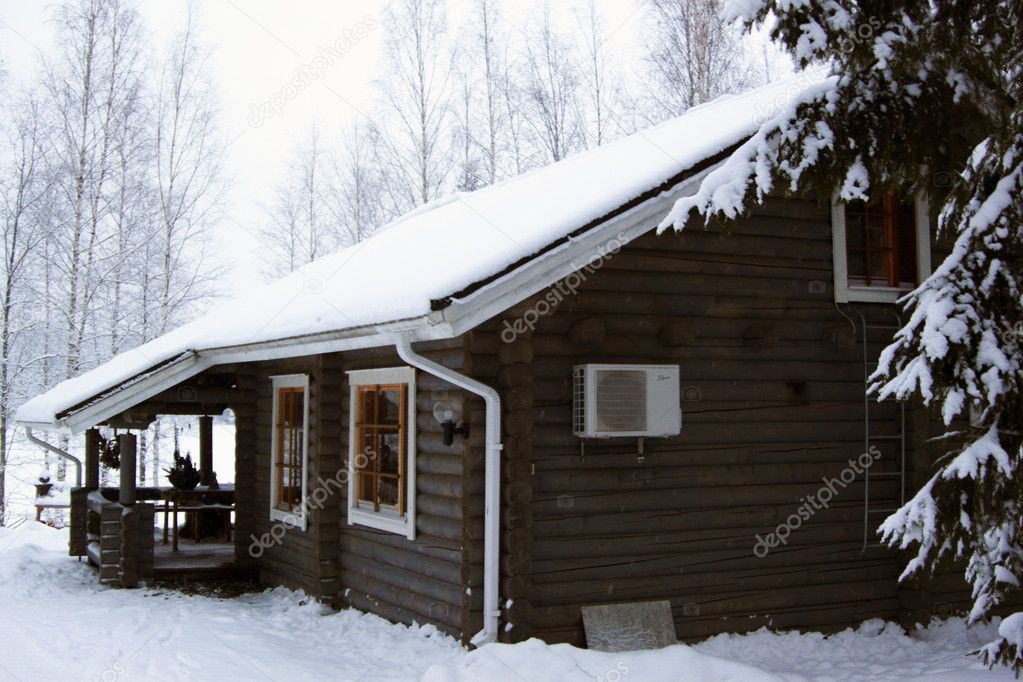 Wooden cottage covered by snow