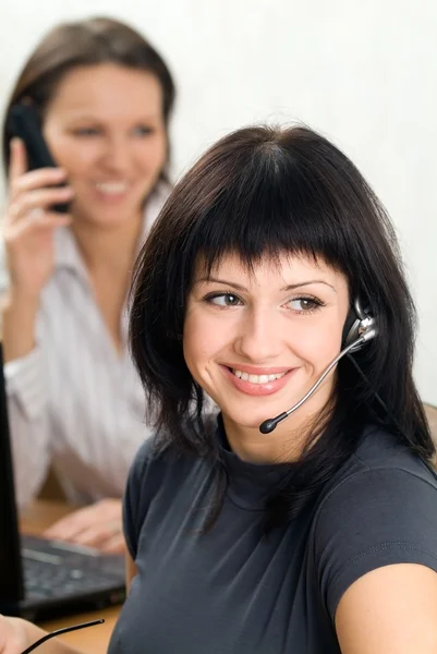 Young brunette with a headset in busines — Stock Photo, Image