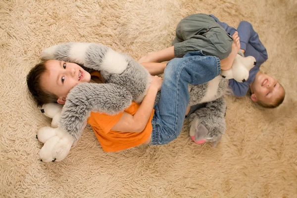 用玩具在地上的两个孩子 — 图库照片