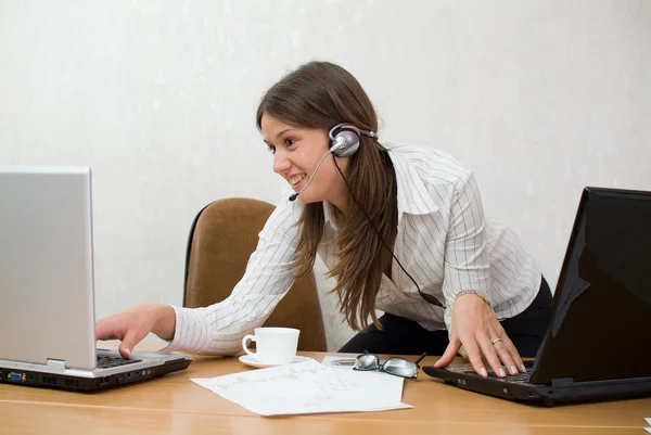 Young businesswoman at the desk with two — Stock Photo, Image