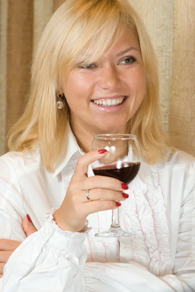Uśmiechający się blond przy lampce czerwonego wina — Zdjęcie stockowe