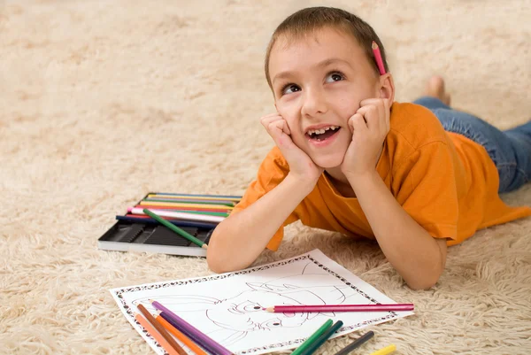 Dziecko z kredki na dywanie. — Zdjęcie stockowe
