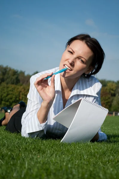 Kobieta, leżąc na trawie z notebookiem — Zdjęcie stockowe