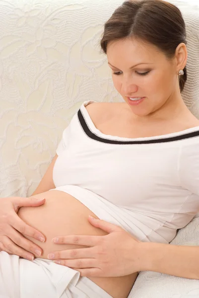 Mulher grávida sentada na cadeira branca — Fotografia de Stock