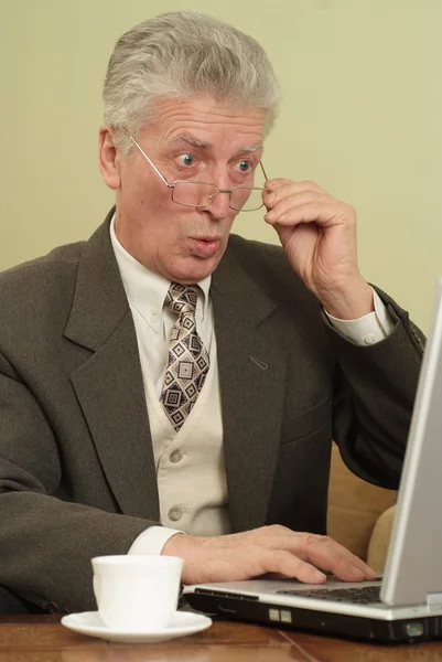 男子坐在看着一台笔记本电脑 — 图库照片