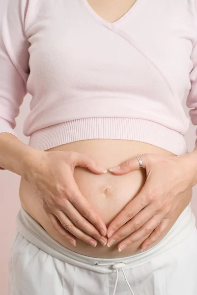 Mujer embarazada sosteniendo su estómago — Foto de Stock